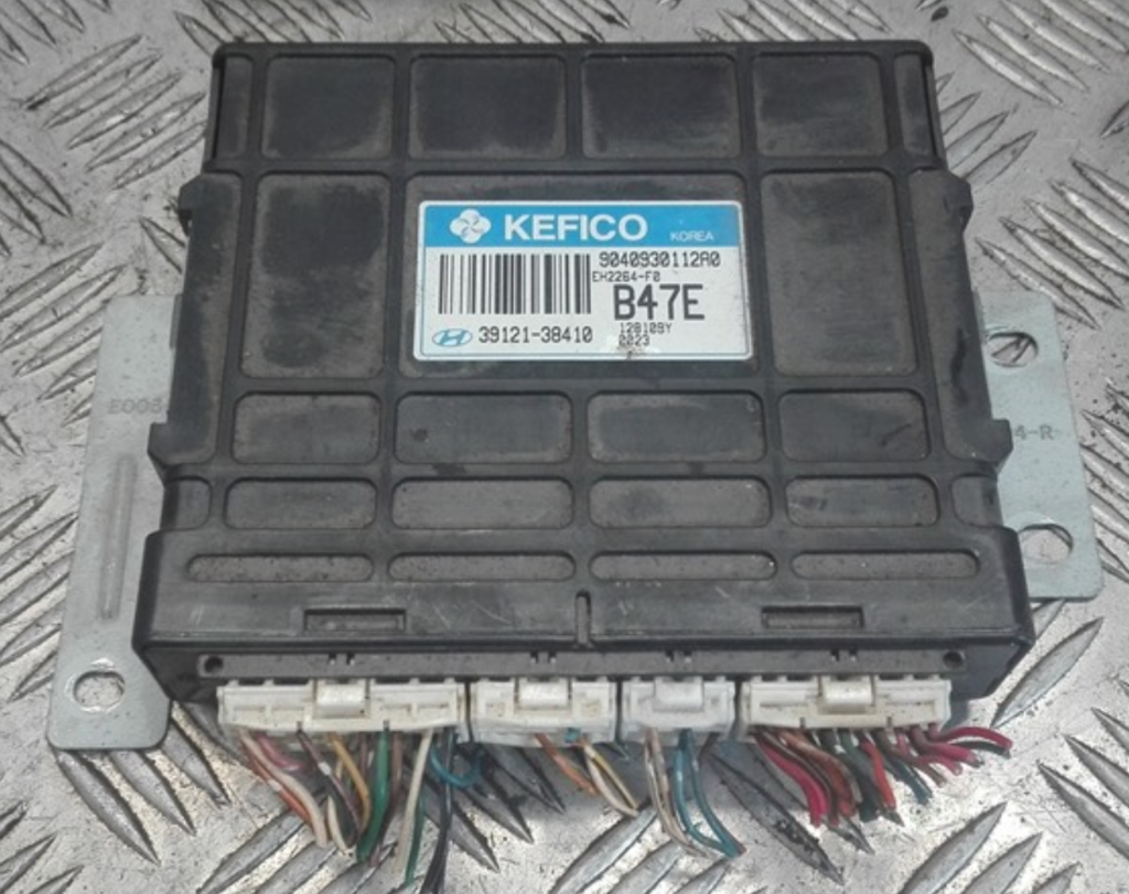 Calculateur moteur KEFICO Hyundai avec connecteurs et faisceau électrique sur fond métallique strié